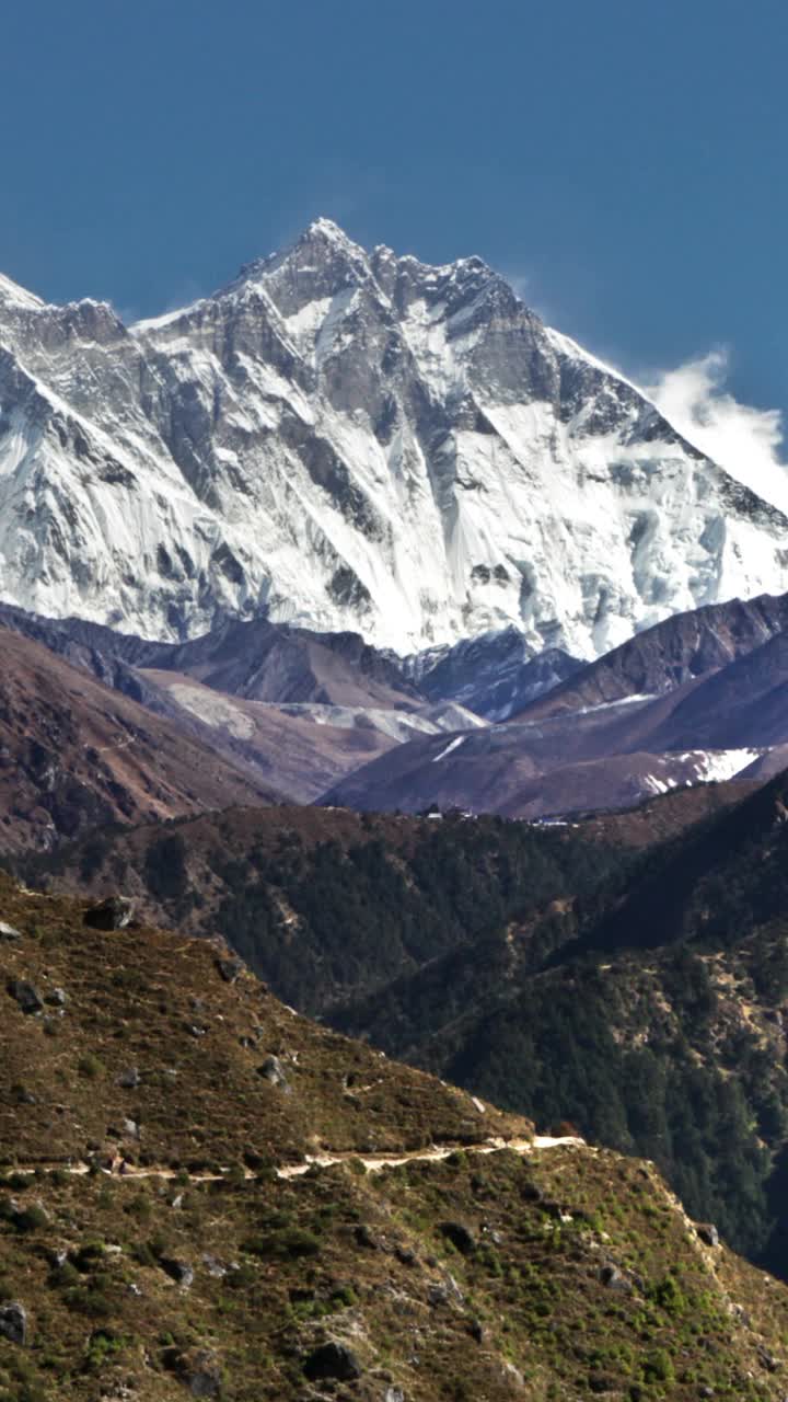 垂直拍摄的时间推移的珠穆朗玛峰和周围的山峰和人们在前景小径。视频素材