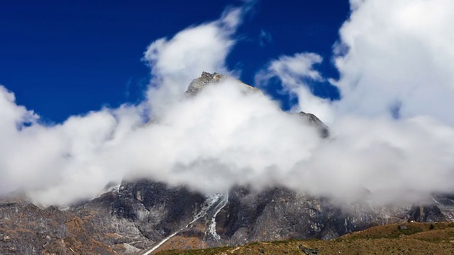 在一个喜马拉雅山峰周围旋转的云的延时平移镜头。视频素材