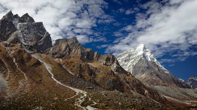 平移拍摄的岩石喜马拉雅山峰和路过的云延时。视频素材