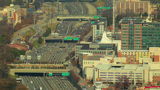 高速公路上流动的汽车和两边的城市建筑的静态广角镜头。视频素材