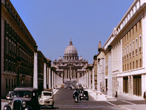 20世纪50年代广角长镜头圣彼得大教堂(Basilica di San Pietro)，前景中有一排排的街道，交通繁忙/梵蒂冈城/罗马，意大利视频素材