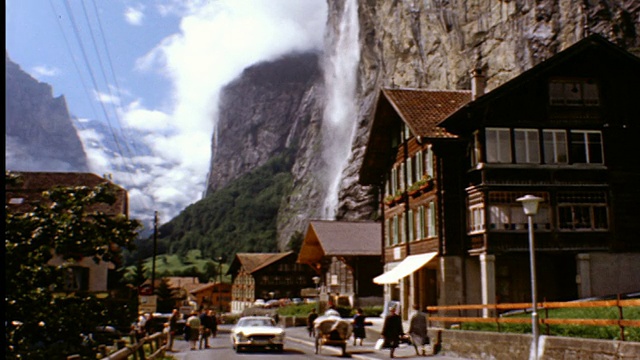 20世纪60年代的人们和汽车在村庄街道上的斯托巴赫瀑布山瀑布/ Lauterbrunnen，瑞士视频素材