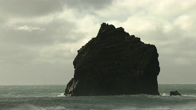 海鸟在冰岛雷克雅内斯半岛海岸附近的玄武岩海堆上飞翔。视频素材