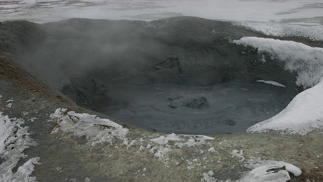 雪落在地热泥浆池上。视频素材