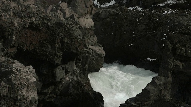 顺着山坡上的溪谷流淌的白水往下流。视频素材