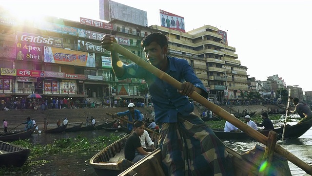 位于孟加拉国达卡的Sadarghat Launch Terminal是一个熙熙攘攘的客运枢纽，在这里，小木船出租车在巨大的钢轮渡旁划行视频素材