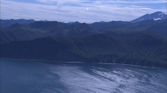 群山高耸于一条平静的河流及其支流之上。视频素材