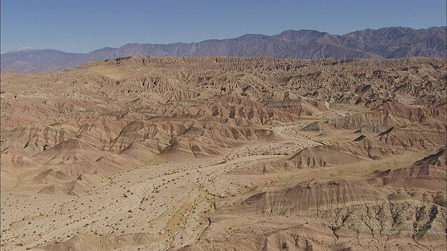 一个布满岩石的沙漠山谷通向一片多山的地平线。视频素材