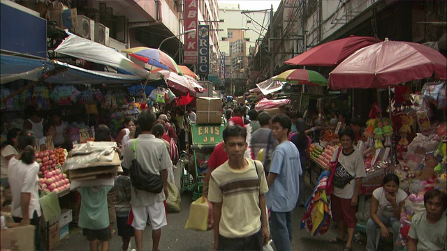 购物者挤满了菲律宾一条繁忙的市场街道。视频素材