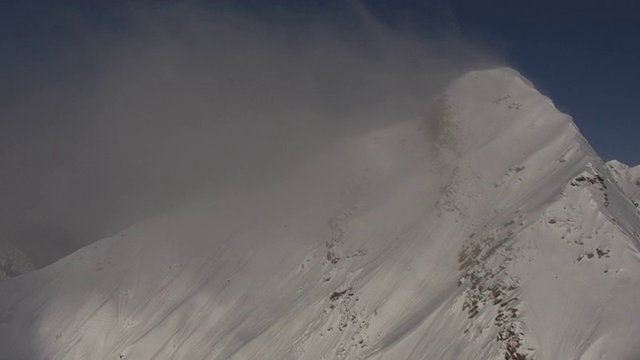 浓雾笼罩着一座白雪皑皑的山峰。视频素材