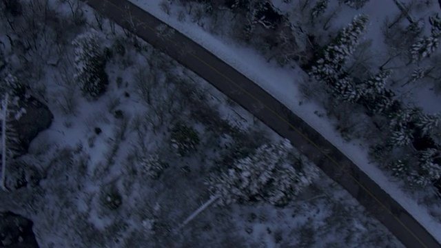 一条狭窄的道路穿过白雪覆盖、树木繁茂的瓦萨奇山脉。视频素材