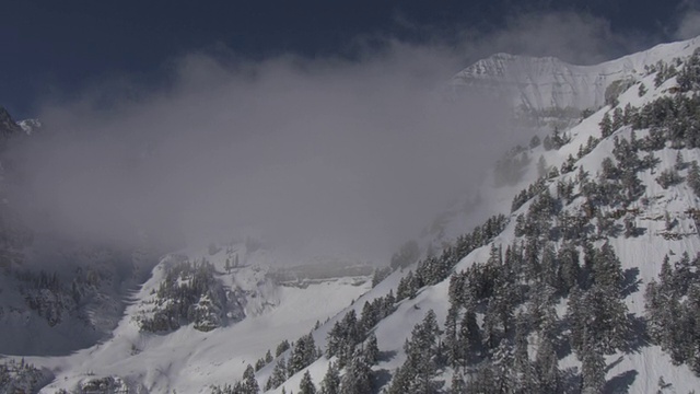 低矮的云层遮住了瓦萨奇山脉覆盖着积雪、树木繁茂的山坡。视频素材