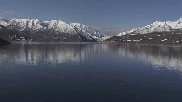 在犹他州，一个宁静的湖映照着白雪覆盖的瓦萨奇山脉。视频素材