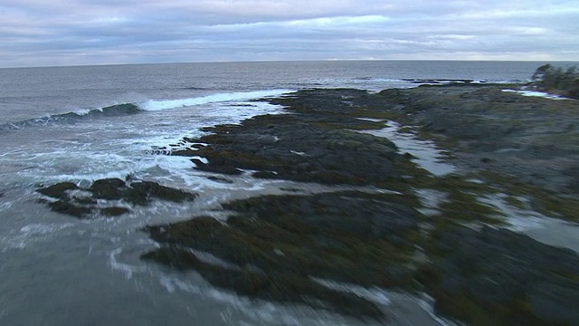 波浪冲击着岛屿的岩石海岸。视频素材