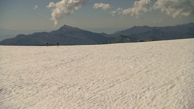 登山者徒步穿越积雪的冰川。视频素材