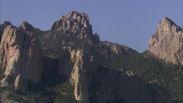 茂密的森林覆盖着崎岖的山峰中的山谷。视频素材