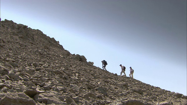 埃及申谢夫，徒步旅行者在沙漠中爬山。视频素材