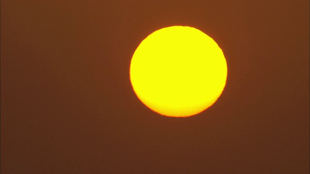 黄色的太阳从橙色的天空升起。视频素材