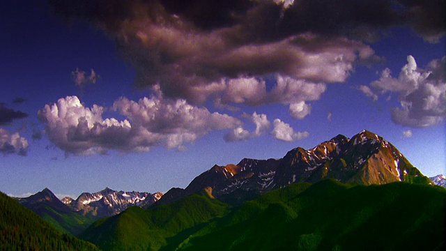 时间流逝云移动在绿色的山在前景+雪山在背景/阿斯彭，科罗拉多州视频素材