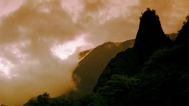 橘色云在山峰周围移动+山顶山谷/天空变暗/夏威夷视频素材