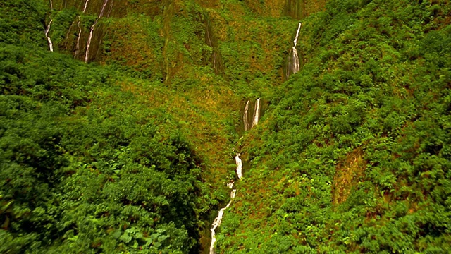 从空中俯瞰郁郁葱葱的山丘和山谷，俯瞰夏威夷瀑布视频素材