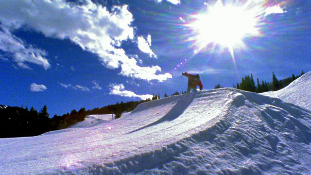 slow motion wide shot PAN man滑雪离开坡道，在空中飞行转弯+翻转/阿斯彭，科罗拉多视频素材