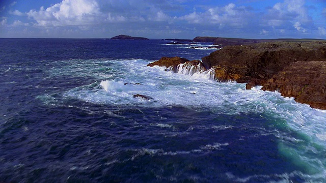 爱尔兰爱尔兰海，空中飞过岩石嶙峋的海岸线和汹涌的海浪视频素材