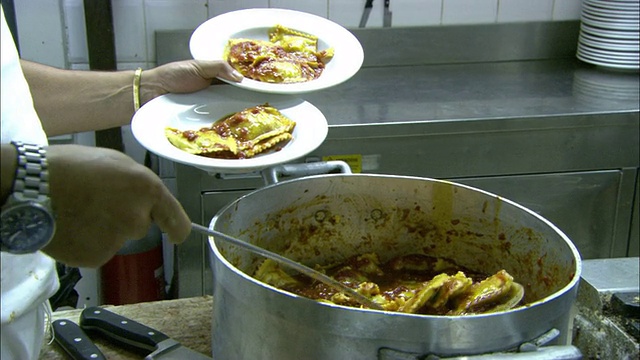 餐馆工作人员在厨房里装食物。视频素材