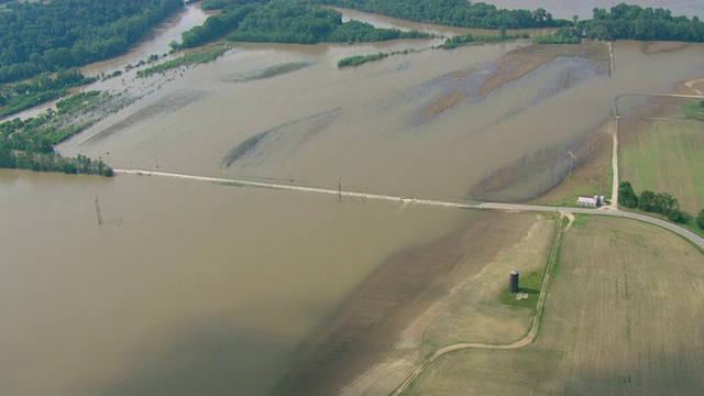 在一个农业区，一条被洪水淹没的道路上方架起了电线。视频素材