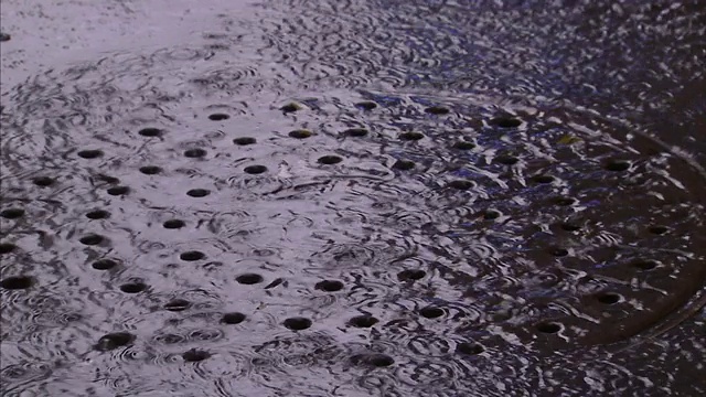 雨水流入纽约市街道上的一个井盖。视频素材