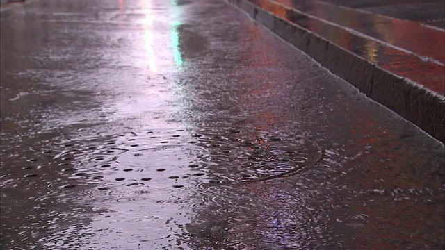 一张纸沿着被雨水浸湿的道路流动。视频素材