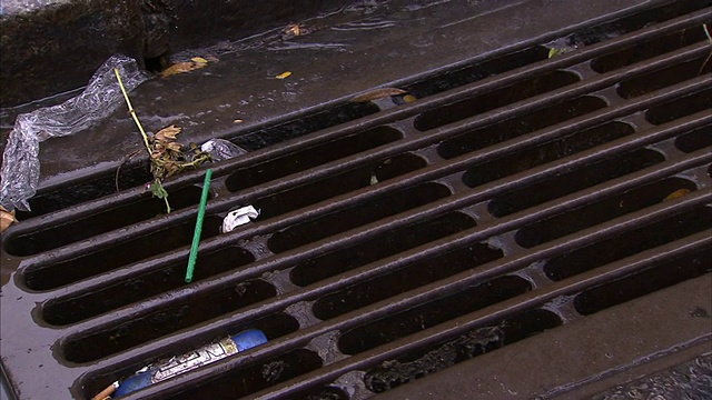 雨水排入纽约市街道上一个装满垃圾的格栅中。视频素材