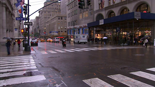 在纽约市的一个雨天，行人穿过东35街的十字路口。视频素材