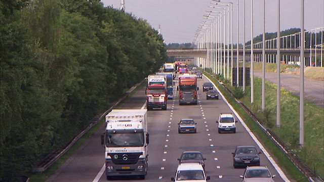 半拖车和汽车在三条车道的高速公路上行驶。视频素材