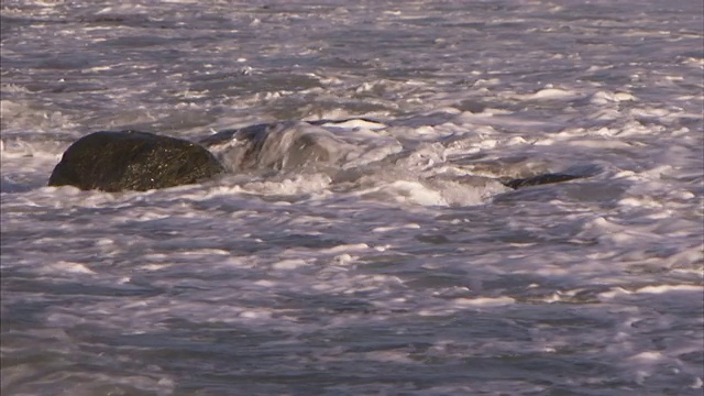 海浪冲刷着海洋中的巨石。视频素材