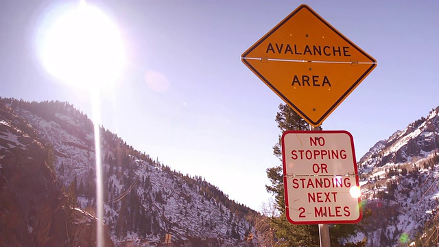 在科罗拉多州一条积雪的山路上，一个路标警告人们雪崩的危险。视频素材