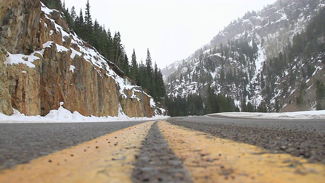 一条双中心线的高速公路穿过科罗拉多州的雪山。视频素材