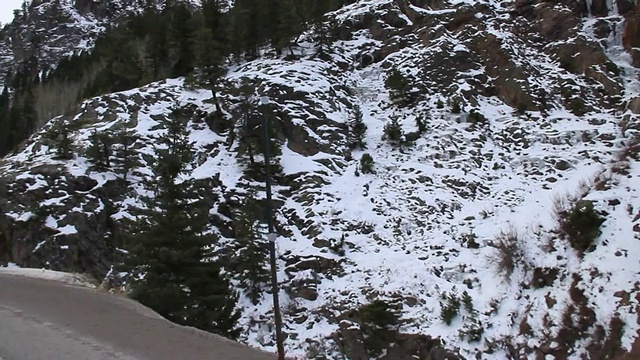 一个路标警告旅客在多雪的山路上有急转弯。视频素材