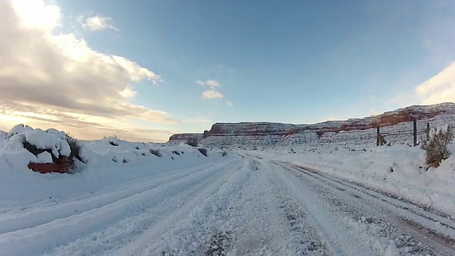 积雪覆盖着牧场和一条通向悬崖的土路。视频素材