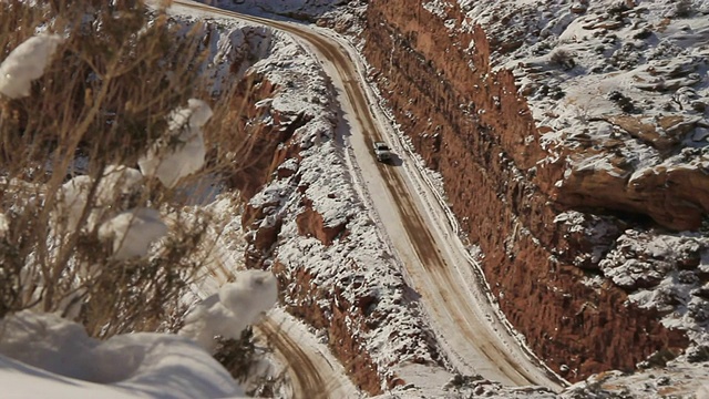 一辆卡车在积雪的山路上行驶。视频素材