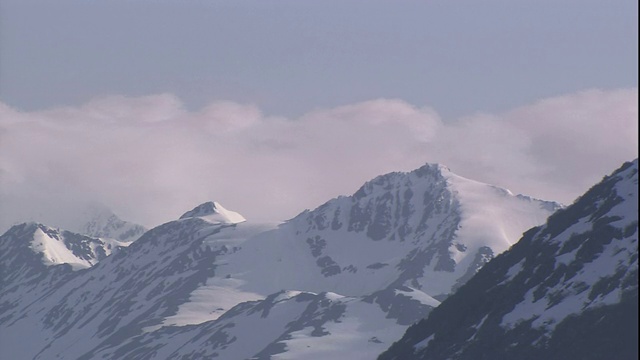 云朵在雪山的山峰上急速掠过。视频素材