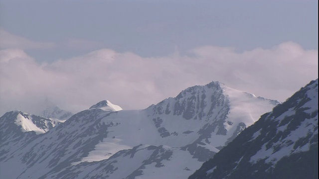 低云环绕着雪山的山峰。视频素材