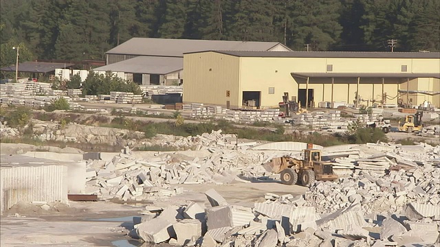 一个前装载机在采石场搬运花岗岩块。视频素材