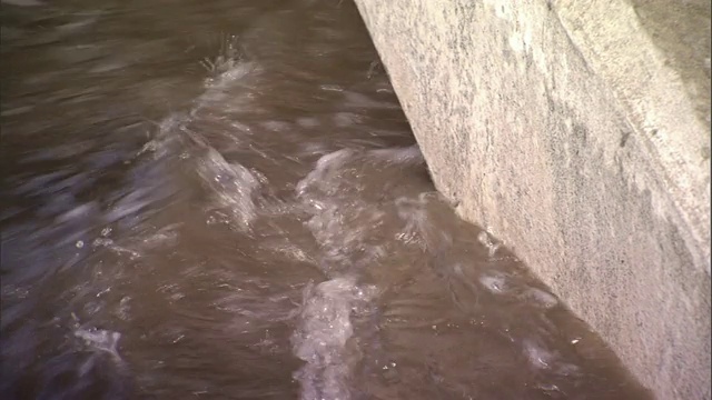 泛滥的河水在桥下湍急地流过。视频素材