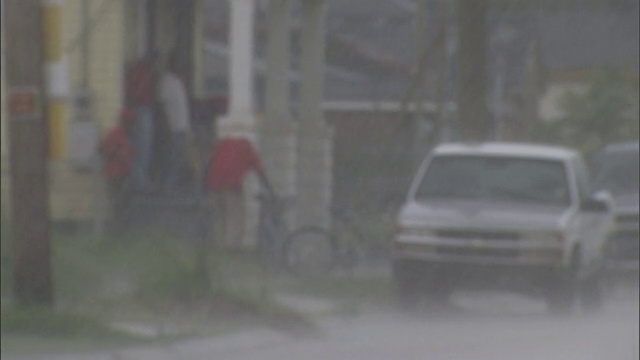 一名居民在暴风雨中丢了一辆自行车，在门廊上寻求庇护。视频素材