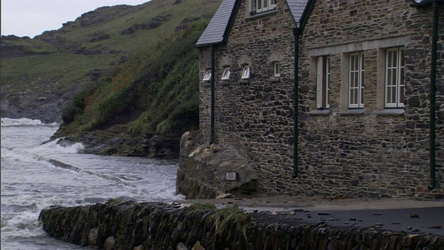 海水在英国Boscastle一处海滨住宅附近搅动。视频素材