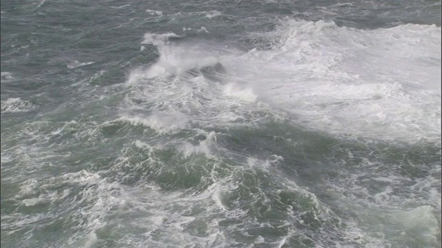 强烈的海浪拍打着海岸的岩石峭壁。视频素材