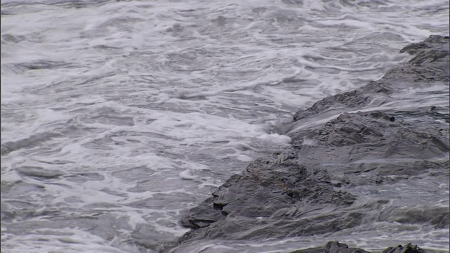 在暴风雨的海面上，波浪冲刷着岩石。视频素材