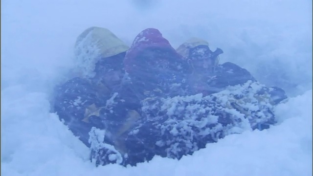 徒步旅行者为了在暴风雪中生存而互相挤作一团。视频素材