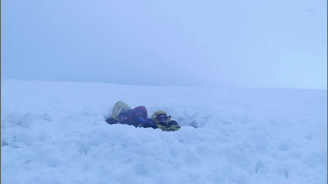 为了在暴风雪中求生，徒步旅行者在雪中挤作一团。视频素材